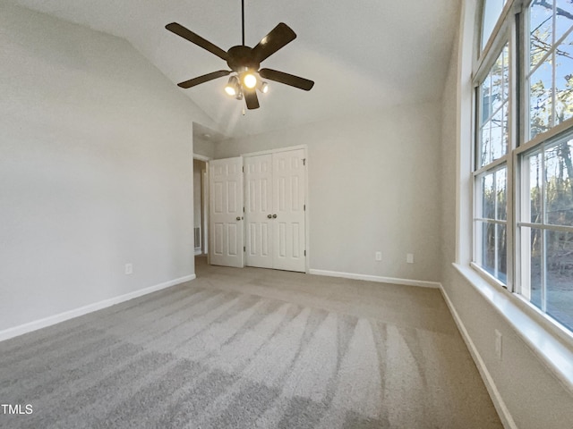 unfurnished bedroom with light carpet, high vaulted ceiling, a closet, and ceiling fan