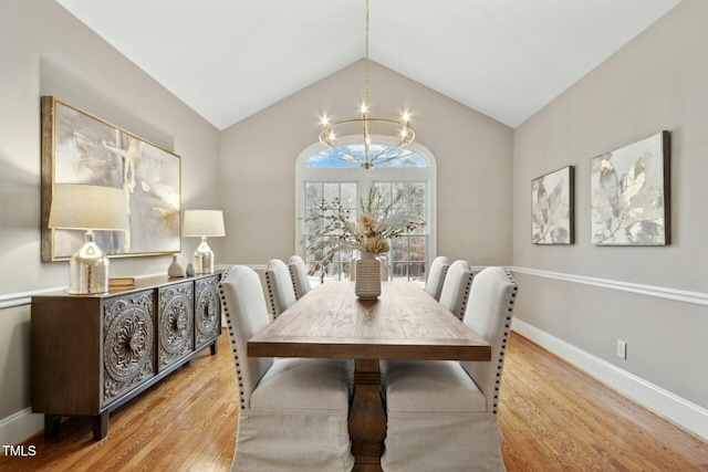 dining area featuring vaulted ceiling, an inviting chandelier, and light wood-type flooring