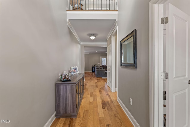 corridor featuring crown molding and light hardwood / wood-style flooring