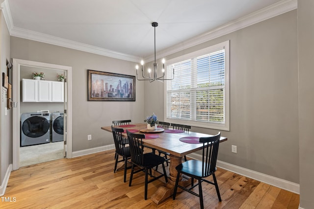 dining room with crown molding, independent washer and dryer, an inviting chandelier, and light hardwood / wood-style flooring