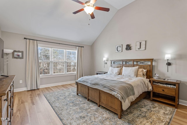 bedroom with ceiling fan, high vaulted ceiling, and light wood-type flooring