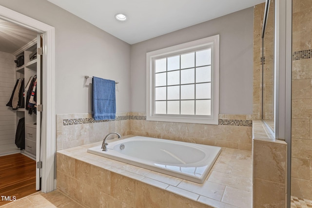 bathroom with a relaxing tiled tub