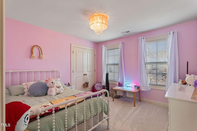 carpeted bedroom with an inviting chandelier and a closet