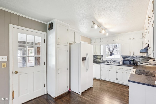 kitchen featuring a sink, dark countertops, range hood, white appliances, and dark wood-style flooring
