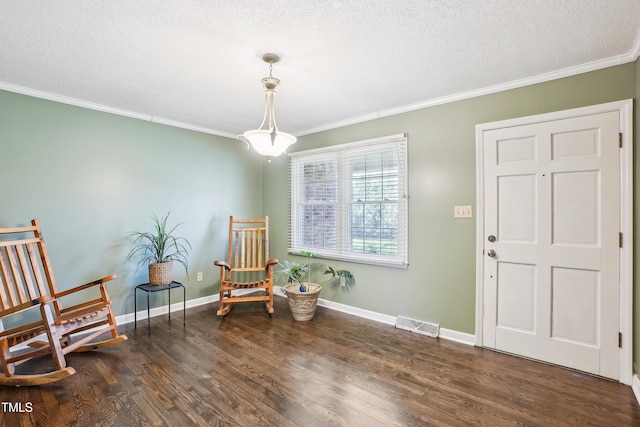 sitting room with ornamental molding, wood finished floors, visible vents, and a textured ceiling