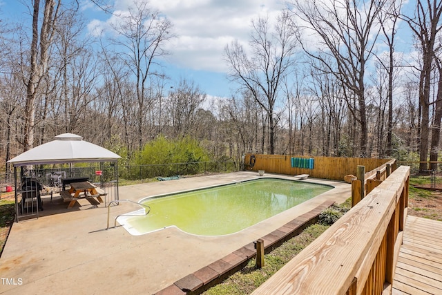 view of pool featuring a fenced in pool, a gazebo, a fenced backyard, a patio, and a diving board