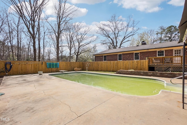 view of pool featuring a fenced in pool, a fenced backyard, a diving board, a deck, and a patio area