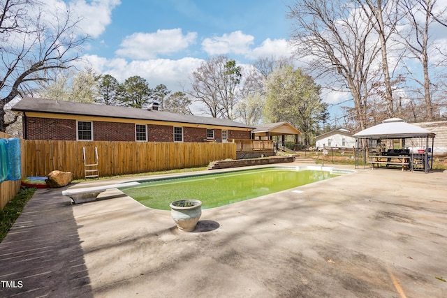 rear view of house featuring a gazebo, brick siding, and fence