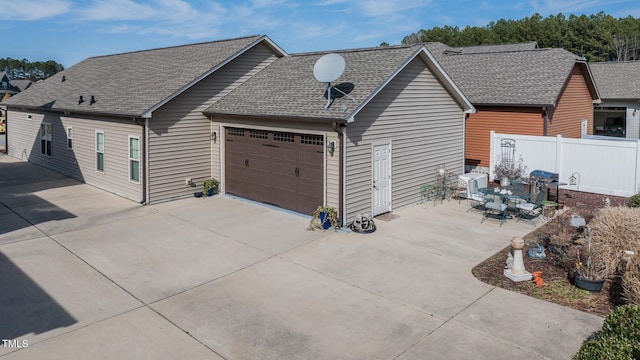 view of home's exterior with a shingled roof and fence