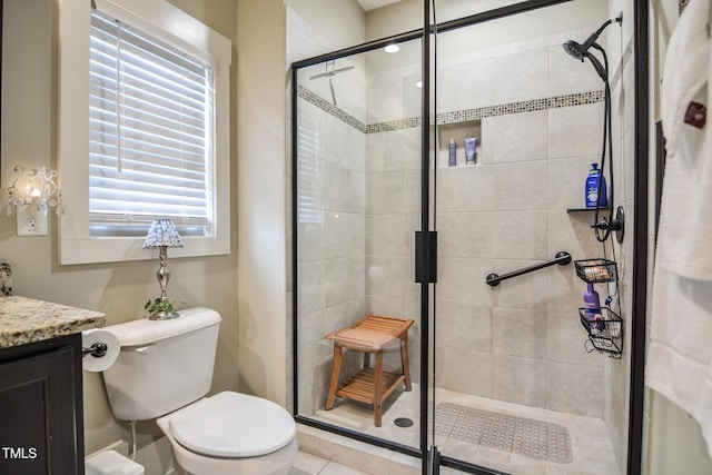 bathroom featuring a shower stall, toilet, and vanity