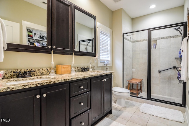 bathroom with a stall shower, a sink, and toilet