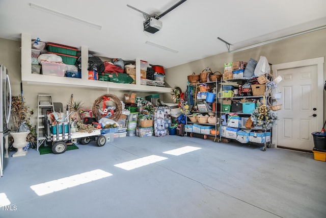 garage with a garage door opener and freestanding refrigerator