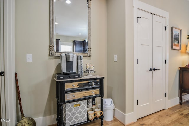 hallway with light wood-type flooring and baseboards