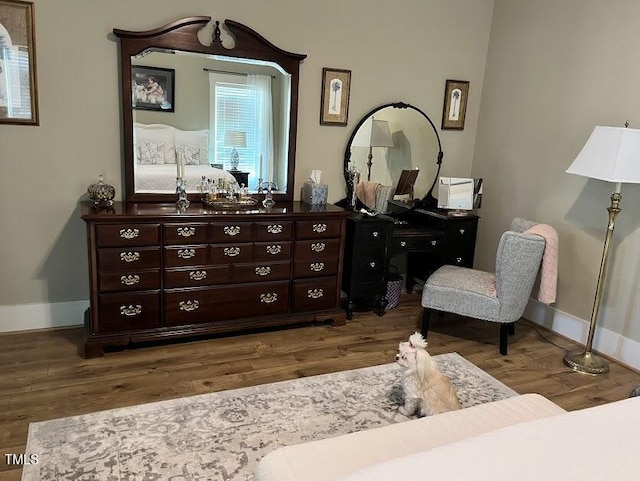 sitting room with baseboards and wood finished floors