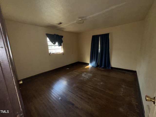 unfurnished room with dark hardwood / wood-style floors