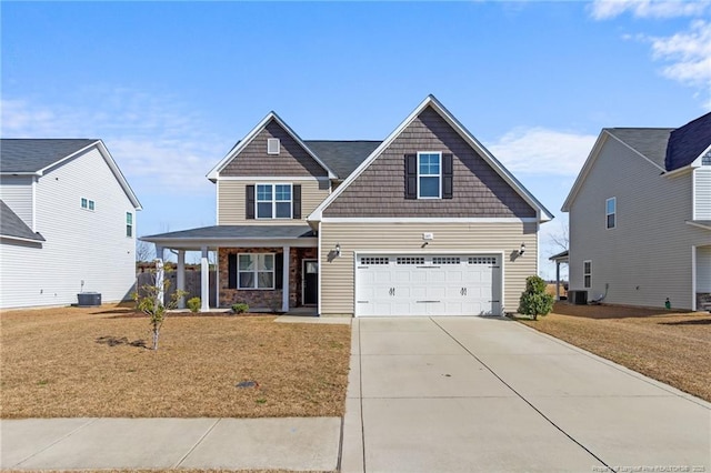 craftsman-style house with a garage, central AC unit, covered porch, and a front yard