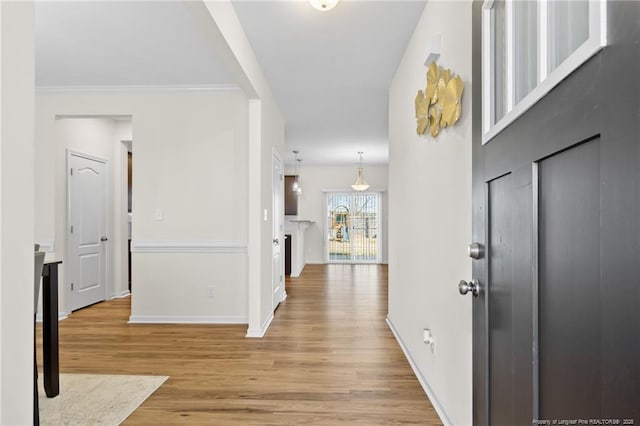 entryway featuring crown molding and light hardwood / wood-style floors