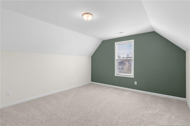 bonus room with carpet flooring and vaulted ceiling