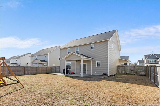 back of property with a playground, a patio, and a yard