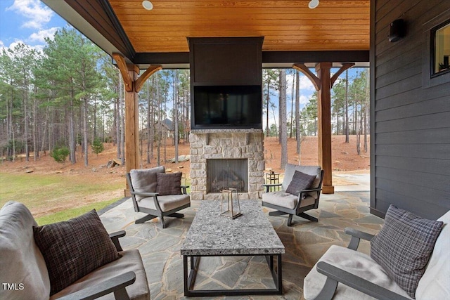 view of patio with an outdoor living space with a fireplace