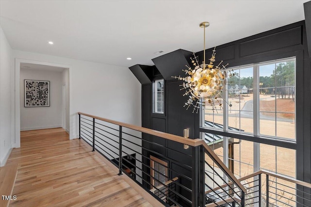 hall featuring wood-type flooring and a chandelier