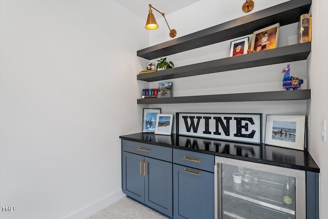 bar with blue cabinets and beverage cooler