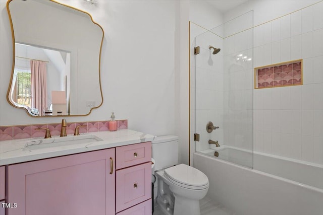 full bathroom with vanity, tiled shower / bath combo, and toilet