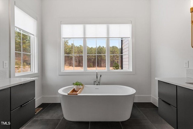 bathroom featuring vanity, a tub to relax in, a wealth of natural light, and tile patterned floors