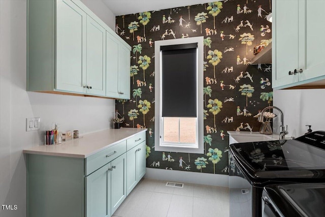 laundry area featuring cabinets, separate washer and dryer, sink, and light tile patterned floors