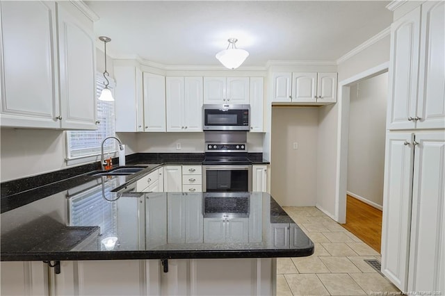 kitchen featuring stainless steel appliances, dark stone countertops, white cabinets, and kitchen peninsula