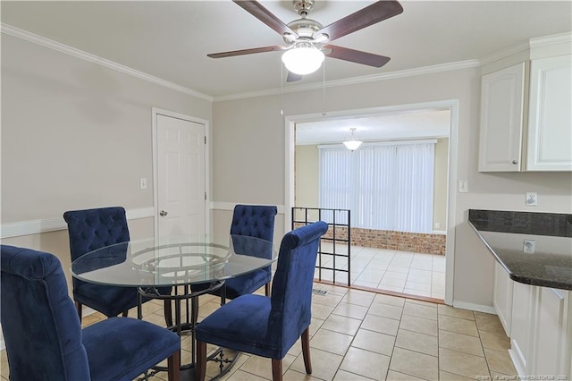 tiled dining area with ceiling fan and ornamental molding