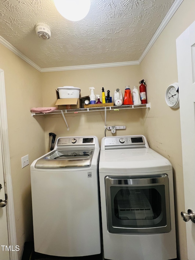 laundry room featuring ornamental molding, washer and clothes dryer, and a textured ceiling