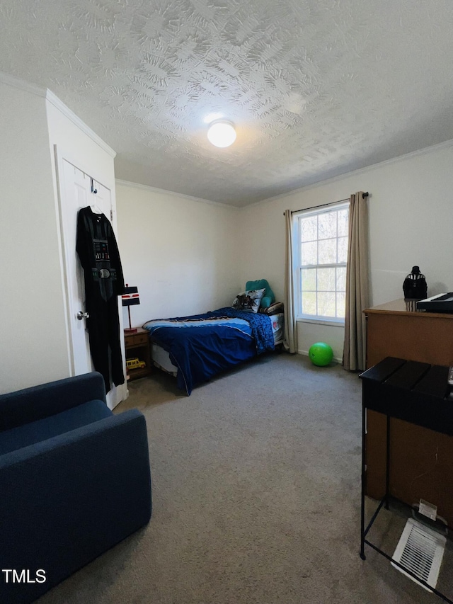 bedroom with ornamental molding, a textured ceiling, and carpet