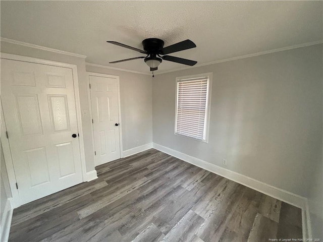 empty room with crown molding, dark hardwood / wood-style floors, and a textured ceiling