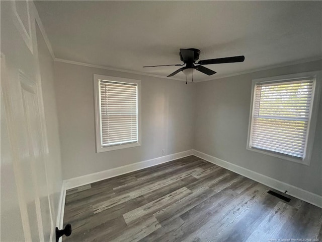 spare room featuring dark wood-type flooring, ornamental molding, and ceiling fan