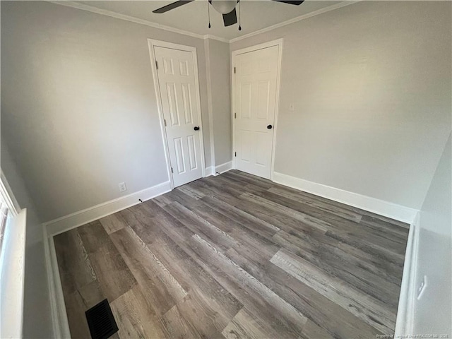 empty room with crown molding, dark hardwood / wood-style floors, and ceiling fan