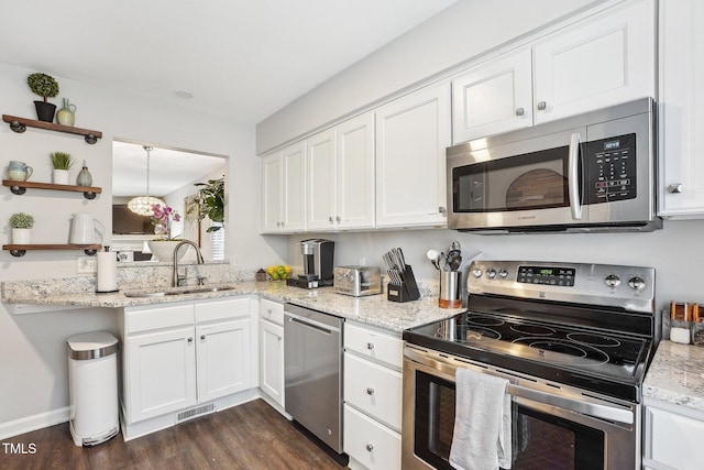 kitchen featuring white cabinetry, stainless steel appliances, light stone countertops, and sink