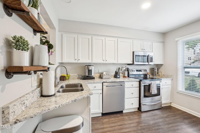 kitchen featuring sink, stainless steel appliances, light stone counters, white cabinets, and dark hardwood / wood-style flooring