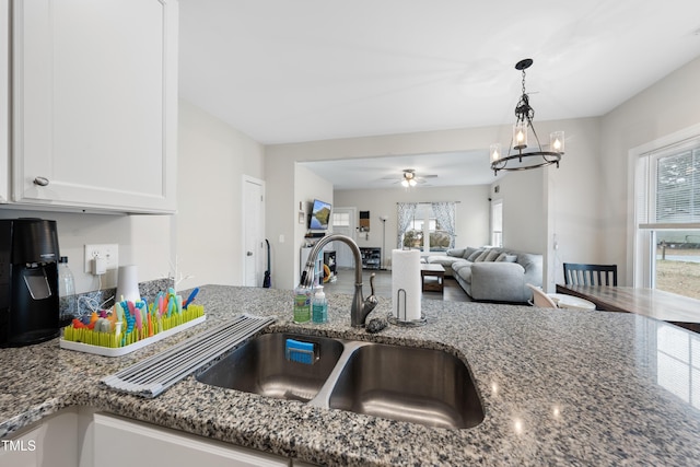 kitchen featuring white cabinetry, sink, and dark stone counters