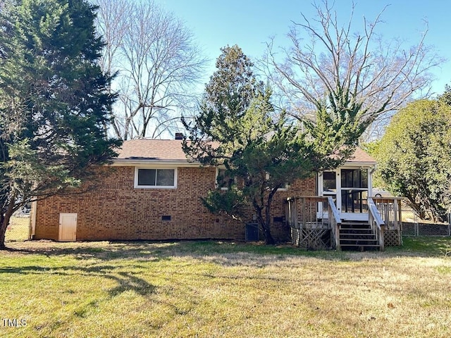 back of property with a lawn, stairway, a sunroom, crawl space, and a chimney
