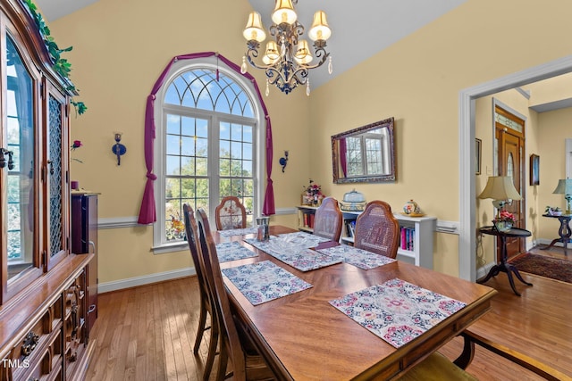 dining area featuring an inviting chandelier, light wood-style flooring, and baseboards