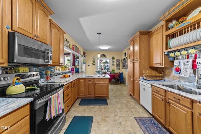 kitchen featuring brown cabinetry, appliances with stainless steel finishes, a peninsula, hanging light fixtures, and backsplash