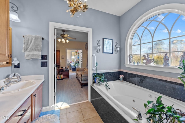 ensuite bathroom featuring ceiling fan, tile patterned floors, a jetted tub, ensuite bathroom, and vanity