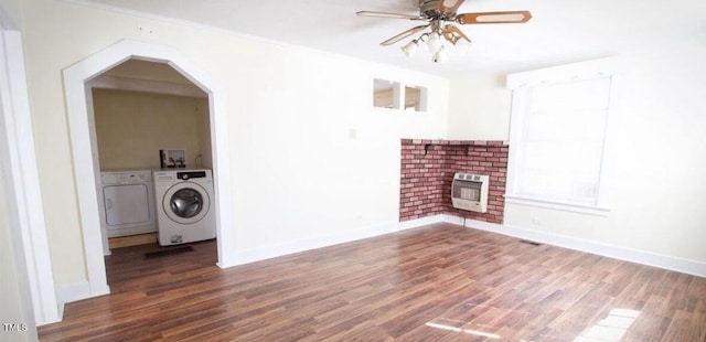 unfurnished living room featuring hardwood / wood-style flooring, heating unit, washing machine and clothes dryer, and ceiling fan