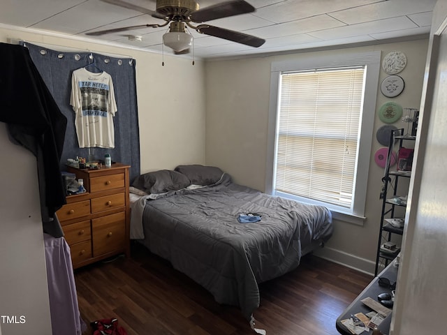 bedroom featuring ceiling fan, dark hardwood / wood-style flooring, and multiple windows