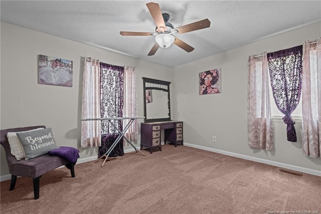 sitting room featuring ceiling fan, a textured ceiling, and carpet flooring