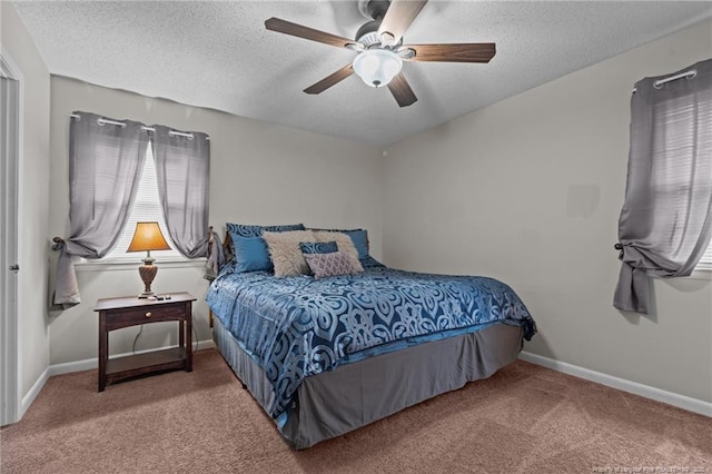 carpeted bedroom with ceiling fan and a textured ceiling