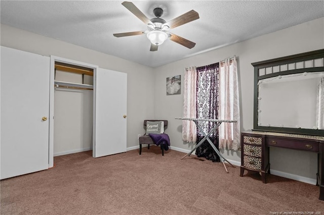 interior space with ceiling fan, carpet floors, and a textured ceiling