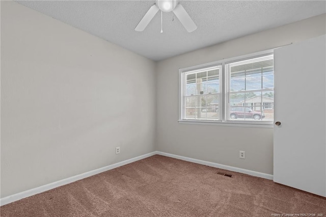 carpeted spare room featuring ceiling fan and a textured ceiling