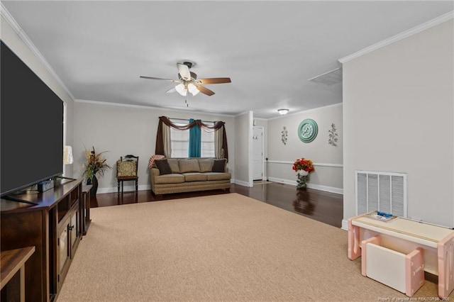 living room with hardwood / wood-style flooring, ceiling fan, and ornamental molding